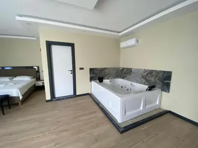 a bathroom with a tub in a room with a bed at Ağva Capella Hideaway Hotel in Sile