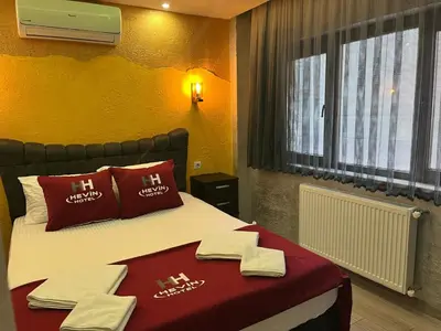 a bedroom with a bed with red pillows and towels at HEVİN Otel in Bursa