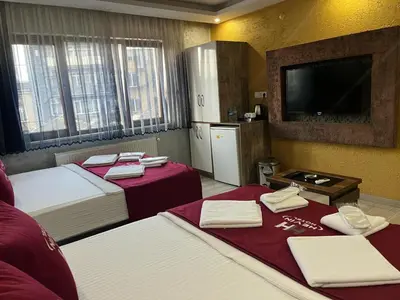 a hotel room with two beds and a flat screen tv at HEVİN Otel in Bursa
