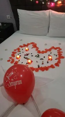 a heart made out of roses on a bed with a red balloon at HEVİN Otel in Bursa