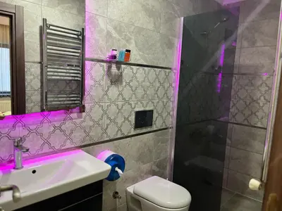 a bathroom with a sink and a shower with purple lighting at HEVİN Otel in Bursa