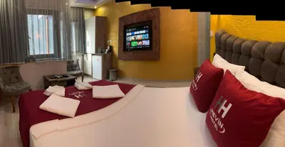 a hotel room with a large bed and a tv at HEVİN Otel in Bursa