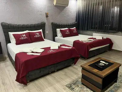 two beds in a hotel room with red pillows at HEVİN Otel in Bursa