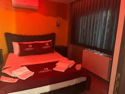 a bedroom with orange walls and a bed with red pillows at HEVİN Otel in Bursa