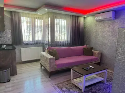 a living room with a purple couch and a table at HEVİN Otel in Bursa