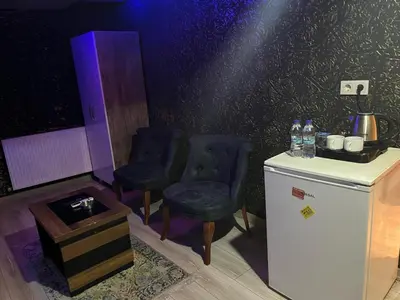 a room with two chairs and a small refrigerator at HEVİN Otel in Bursa