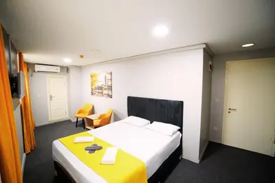 a hotel room with a bed and a yellow table at Polo Suit Otel in Avcılar