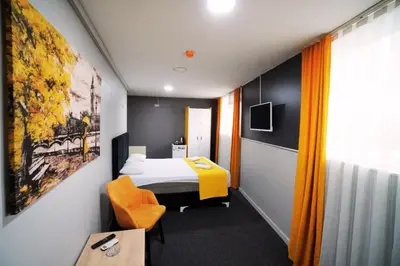 a hotel room with a bed and a yellow chair at Polo Suit Otel in Avcılar