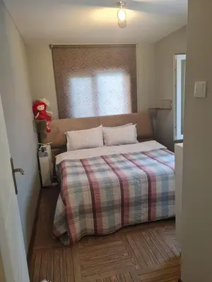 a small bedroom with a bed with a plaid blanket at villa SM in Çatalca