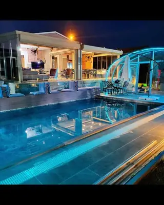 a swimming pool in front of a house at night at villa SM in Çatalca