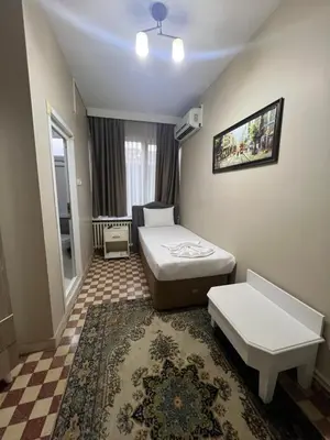 a hotel room with a bed and a table and a couch at Fındık Palas Otel in Istanbul