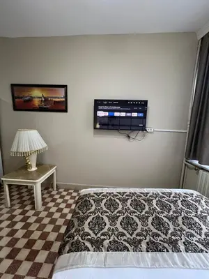 a bedroom with a bed and a tv on the wall at Fındık Palas Otel in Istanbul