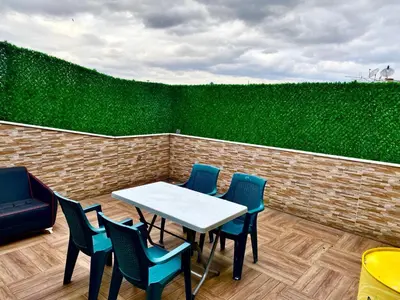 a table and chairs on a patio with a green hedge at My King Suit in Istanbul