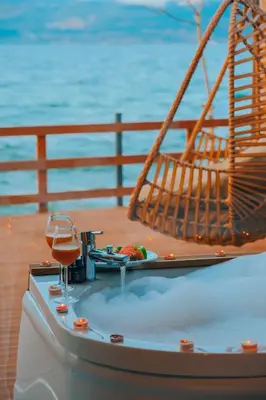 a bath tub with a glass of wine on a table at Flamingo Adalife in Sapanca