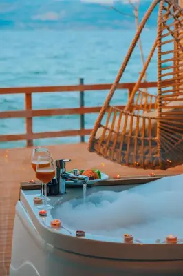 a hot tub with a glass of wine on a table at Flamingo Adalife in Sapanca
