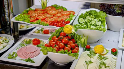 a buffet with tomatoes lettuce and other vegetables in bowls at Kent Hotel Beyazıt in Istanbul