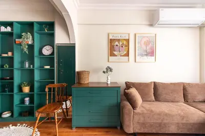a living room with a couch and green shelves at Chic 2BR Gem on Moda Iconic Antiques Street in Istanbul