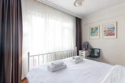 a bedroom with a white bed with two towels on it at Chic 2BR Gem on Moda Iconic Antiques Street in Istanbul