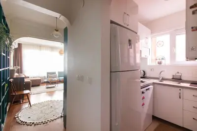 a kitchen with a white refrigerator and a living room at Chic 2BR Gem on Moda Iconic Antiques Street in Istanbul