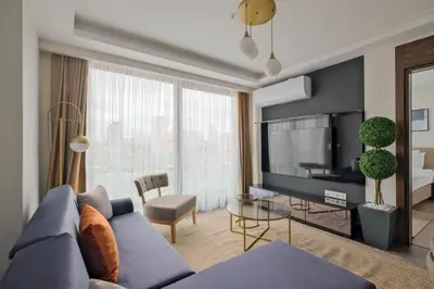 a living room with a blue couch and a tv at Modern Furnished Apartments in Istanbul Basaksehir By Iradah Gayrimenkul in Basaksehir
