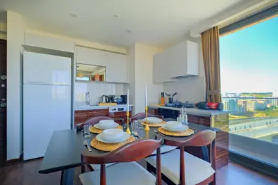 a kitchen with a dining table and chairs and a kitchen at Modern Furnished Apartments in Istanbul Basaksehir By Iradah Gayrimenkul in Basaksehir