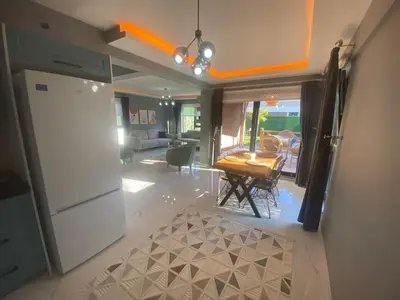 a kitchen and living room with a refrigerator and a table at Lina Garden Villa in Sapanca