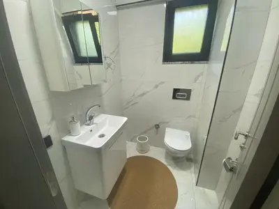 a white bathroom with a toilet and a sink at Lina Garden Villa in Sapanca