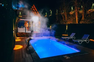 a large swimming pool at night with a light at Mert Bungalov-Ay Evi in Sapanca