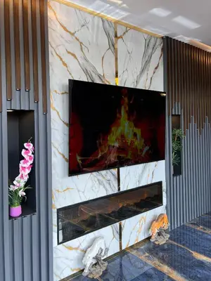 a fireplace with a tv on a wall at City Night Hotels Ümraniye in Umraniye