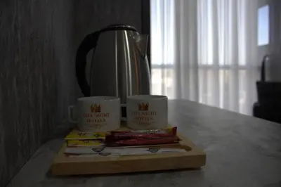 a table with three coffee cups and books on it at City Night Hotels Ümraniye in Umraniye