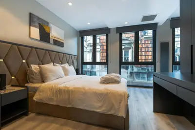 a bedroom with a bed and a desk and windows at DeCamondo Residence Karaköy in Istanbul