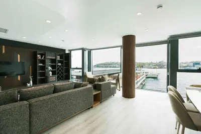 a living room with a large couch and a view of the water at DeCamondo Residence Karaköy in Istanbul