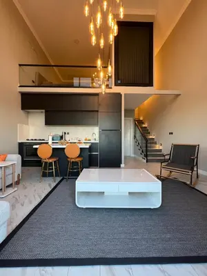 a living room with a white table and a kitchen at Loft Sabırlı in Kaynarca