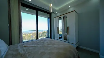 a bedroom with a large bed and large windows at 4 Mevsim Konak in Kartepe