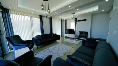 a living room with a couch and chairs and a tv at 4 Mevsim Konak in Kartepe
