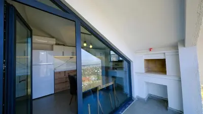 a kitchen with glass doors and a table in a room at 4 Mevsim Konak in Kartepe