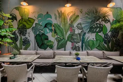 a room with tables and a mural of plants at Ayramin Deluxe Hotel Taksim in Istanbul