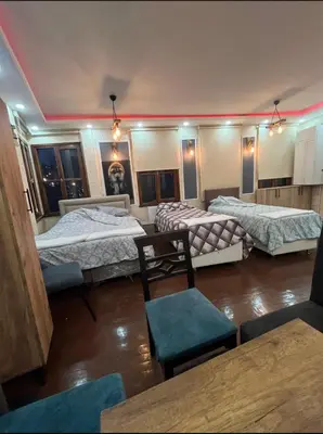 a room with three beds and a table and chairs at Müstakil kat 2 in Istanbul