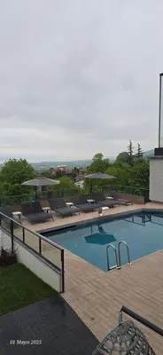 a swimming pool with lounge chairs and umbrellas at 4 Mevsim Konak in Kartepe