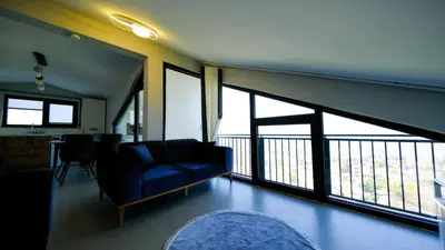a living room with a blue couch and large windows at 4 Mevsim Konak in Kartepe