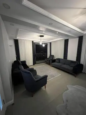 a living room with black couches and a fireplace at 4 Mevsim Konak in Kartepe