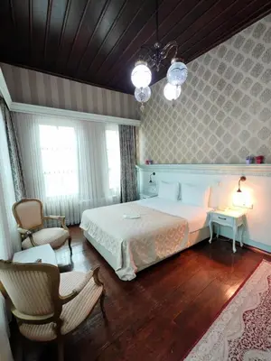 a bedroom with a large bed and two chairs at Bursa İpekyolu Hotel in Bursa