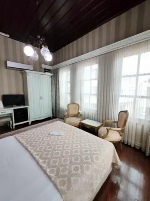a bedroom with a bed and chairs and a tv at Bursa İpekyolu Hotel in Bursa