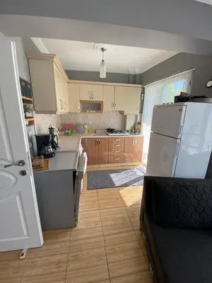 a kitchen with a white refrigerator and wooden cabinets at Sidelya in Ocaklar