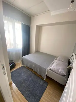 a small bedroom with a bed and a blue rug at Sidelya in Ocaklar