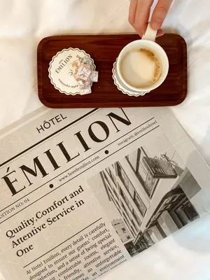 a person holding a cup of coffee next to a newspaper at Emilion Hotel in Istanbul