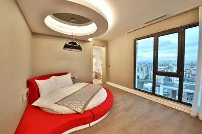 a bedroom with a red bed and a large window at Bof Hotels Ceo Suites Atasehir in Istanbul