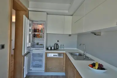 a kitchen with white cabinets and a bowl of fruit on the counter at Bof Hotels Ceo Suites Atasehir in Istanbul