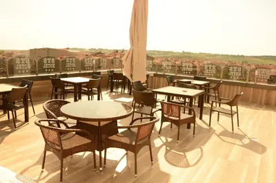 a patio with tables and chairs on a balcony at STS Hotel Luleburgaz in Lüleburgaz