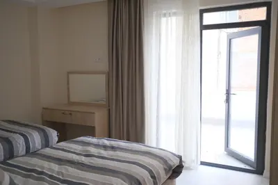 a bedroom with a bed and a sliding glass door at STS Hotel Luleburgaz in Lüleburgaz